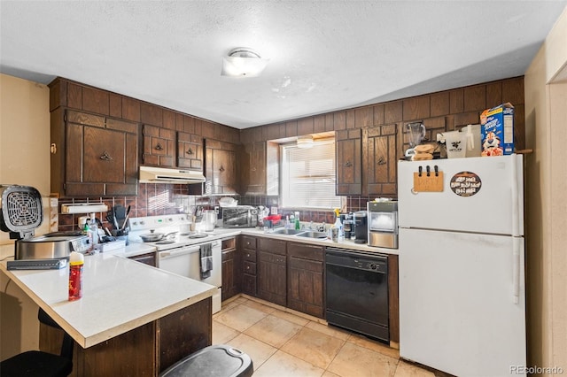 kitchen featuring dark brown cabinetry, a kitchen breakfast bar, kitchen peninsula, a textured ceiling, and white appliances