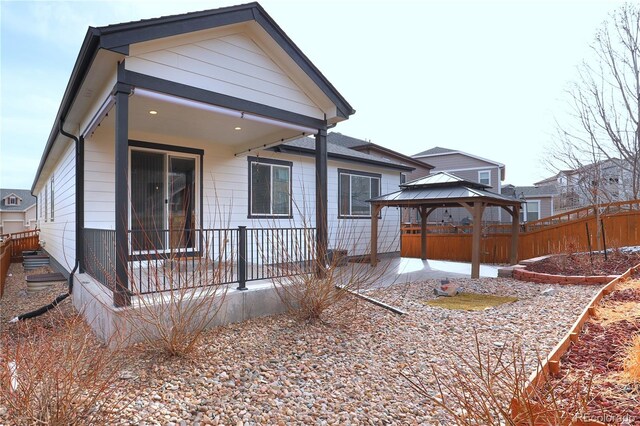 rear view of property with a gazebo and fence