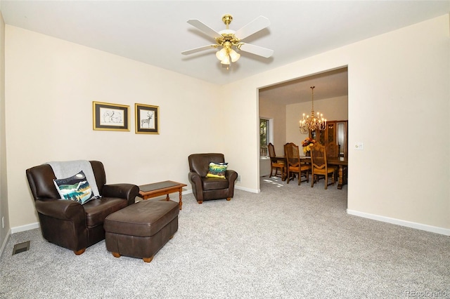 sitting room featuring ceiling fan with notable chandelier, baseboards, visible vents, and carpet floors