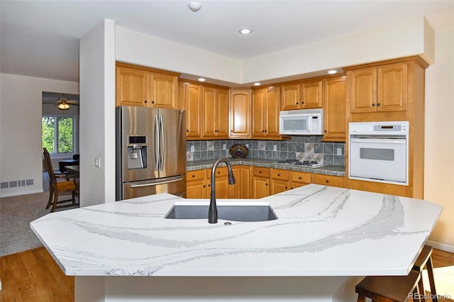 kitchen with visible vents, backsplash, appliances with stainless steel finishes, and a sink