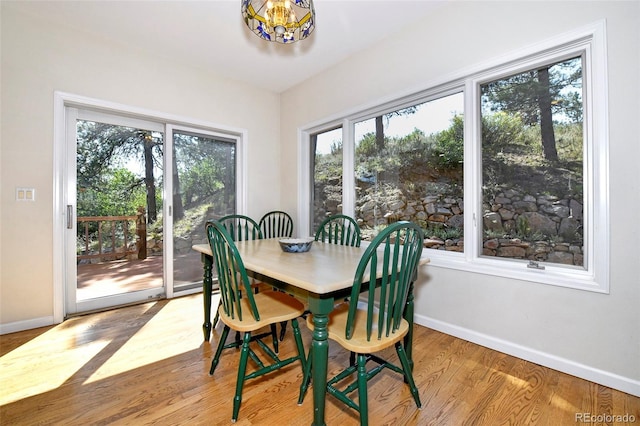 dining area with a chandelier, baseboards, and wood finished floors