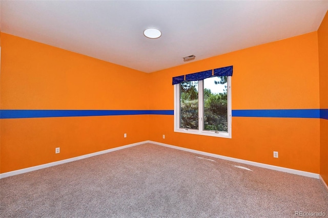 unfurnished room featuring visible vents, baseboards, and carpet