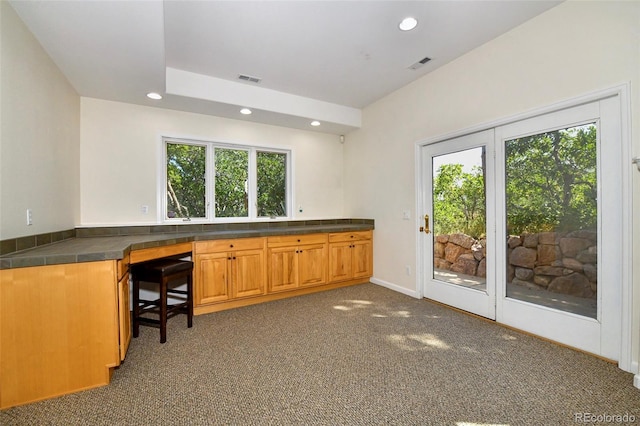 kitchen featuring carpet, recessed lighting, a healthy amount of sunlight, and built in desk