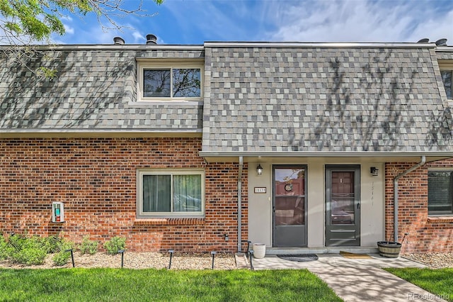 15139 E Wesley Ave, Aurora, CO 80014 - view of property featuring brick siding, roof with shingles, and mansard roof