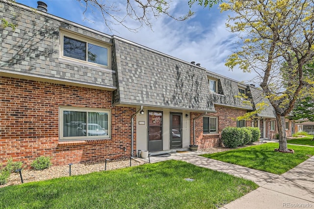 15139 E Wesley Ave, Aurora, CO 80014 - view of front facade with mansard roof, a front yard, brick siding, and roof with shingles
