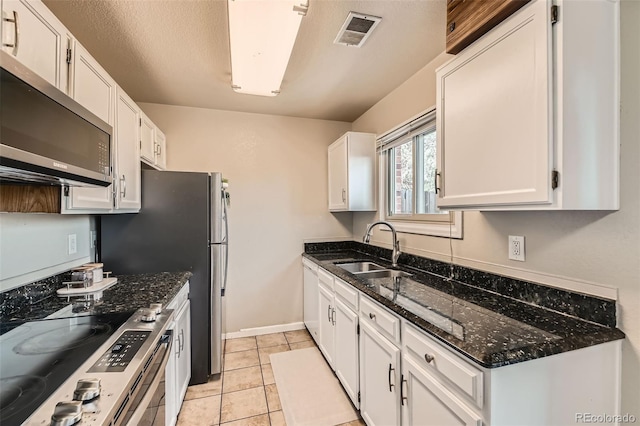 15139 E Wesley Ave, Aurora, CO 80014 - kitchen with appliances with stainless steel finishes, a sink, white cabinetry, dark stone counters, and baseboards