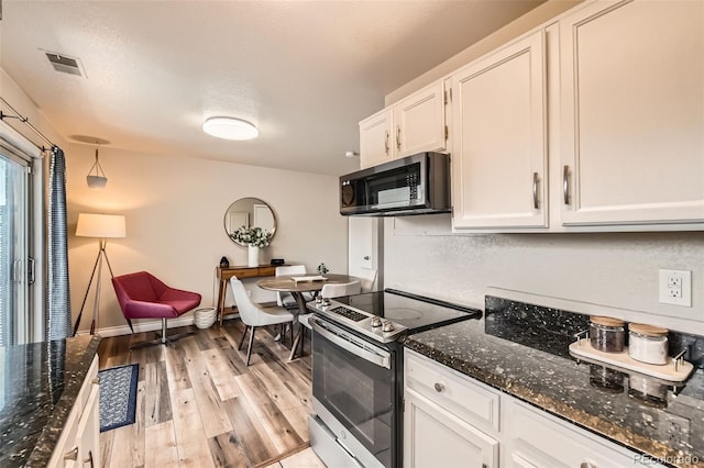 15139 E Wesley Ave, Aurora, CO 80014 - kitchen with stainless steel appliances, white cabinets, light wood-style floors, dark stone countertops, and baseboards