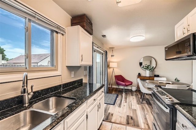 15139 E Wesley Ave, Aurora, CO 80014 - kitchen featuring appliances with stainless steel finishes, a sink, white cabinets, and healthy amount of natural light