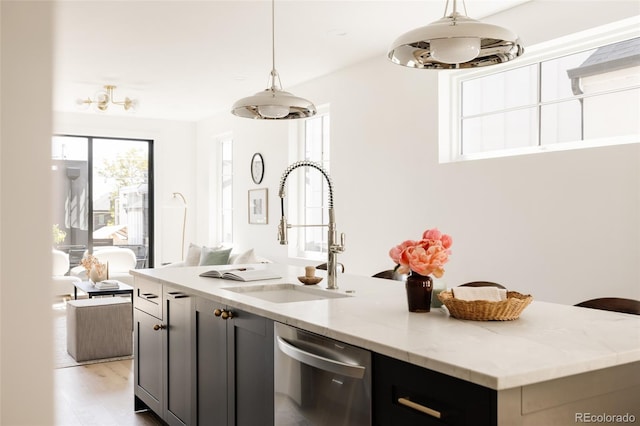 3932 Kalamath St, Denver, CO 80211 - kitchen with a sink, stainless steel dishwasher, a center island with sink, light stone counters, and pendant lighting