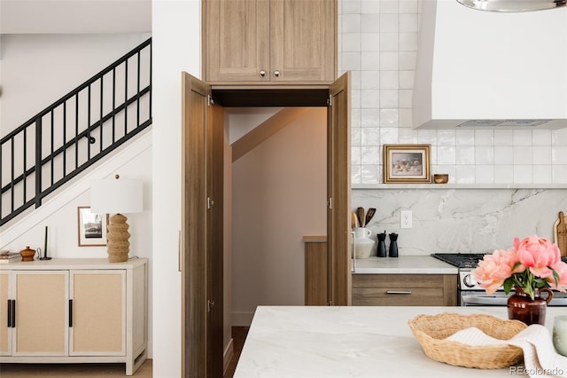 3932 Kalamath St, Denver, CO 80211 - kitchen featuring gas range, tasteful backsplash, and wall chimney exhaust hood
