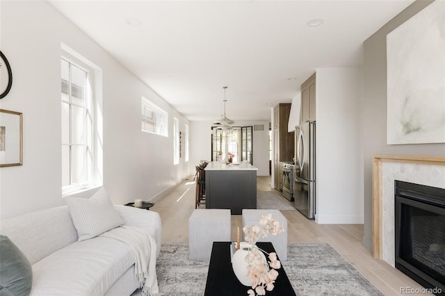 3932 Kalamath St, Denver, CO 80211 - living area featuring light wood-style flooring, a premium fireplace, and baseboards