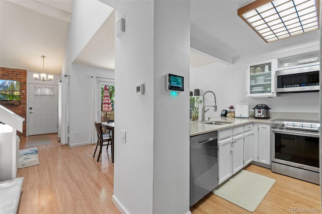 2092 S Helena St Unit C, Aurora, CO 80013 - kitchen featuring appliances with stainless steel finishes, light wood finished floors, light countertops, white cabinets, and vaulted ceiling