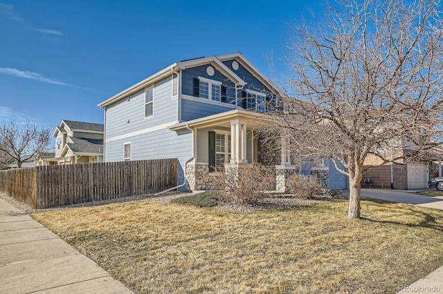 view of front of home featuring a front lawn, a balcony, fence, and a garage