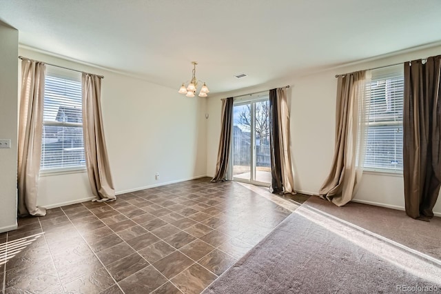 spare room featuring visible vents, baseboards, and a notable chandelier