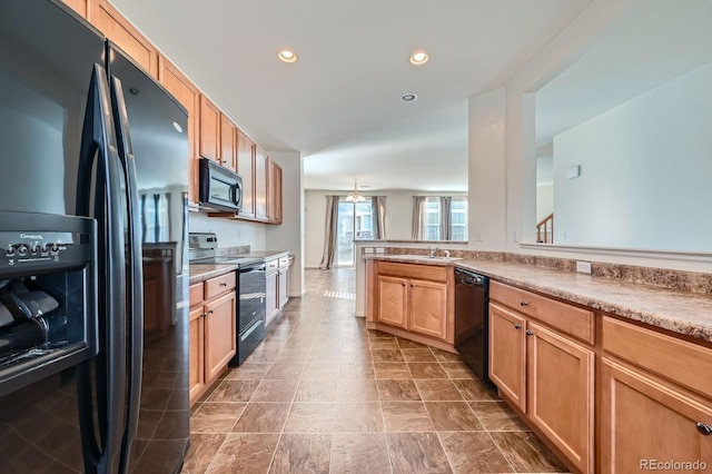 kitchen featuring recessed lighting, black appliances, light countertops, and a sink