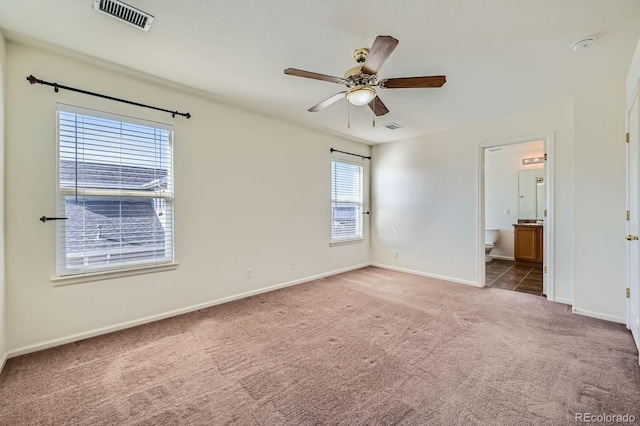 unfurnished bedroom with carpet, visible vents, ensuite bathroom, and baseboards