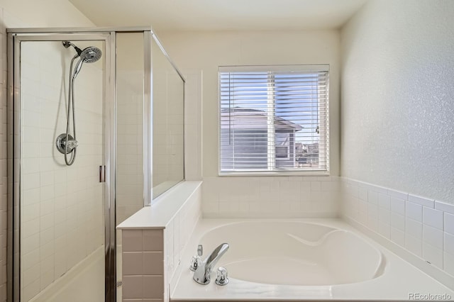 full bath with a garden tub, a stall shower, and a textured wall