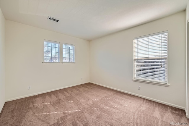 spare room featuring visible vents, baseboards, and carpet flooring