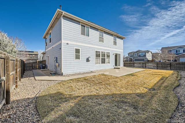 rear view of property featuring a yard, a patio, and a fenced backyard