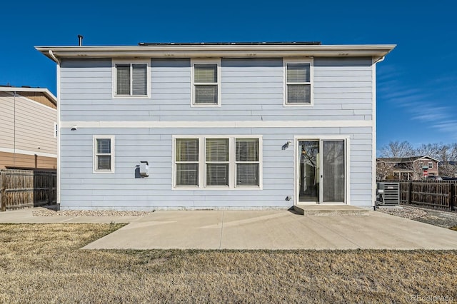 back of property with fence, central AC, a lawn, and a patio area