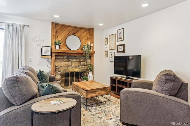 living room featuring a stone fireplace and hardwood / wood-style flooring