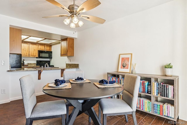 dining space featuring ceiling fan, sink, and dark hardwood / wood-style flooring