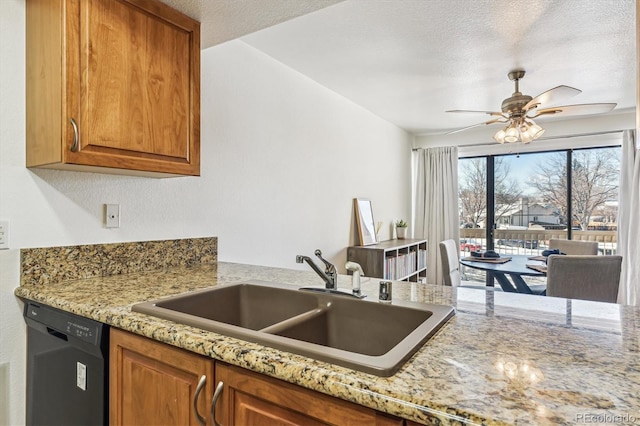 kitchen with dishwasher, light stone countertops, sink, and a textured ceiling