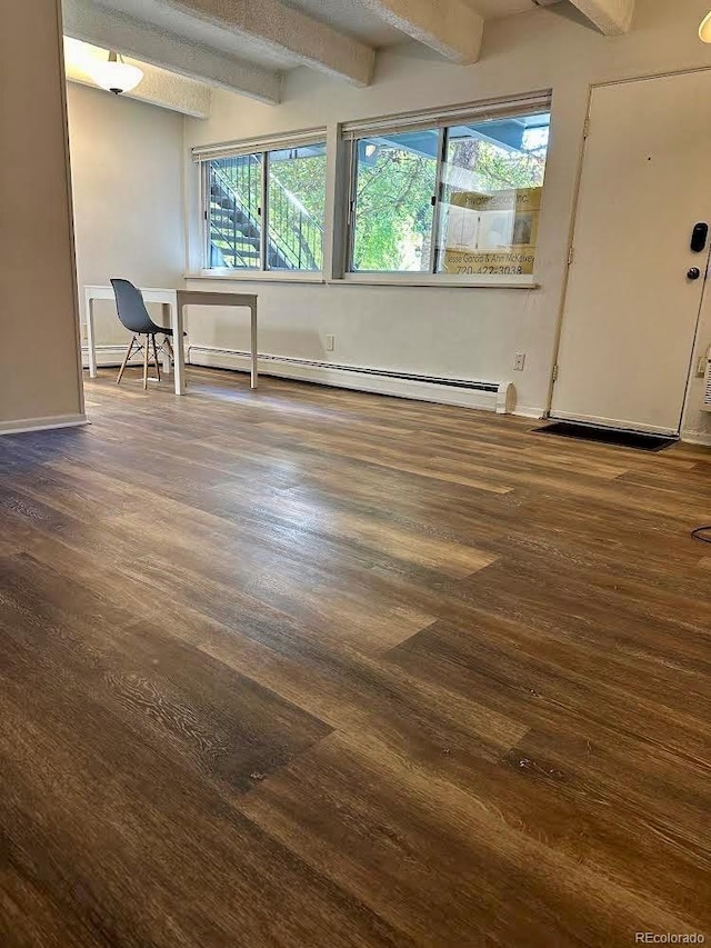 spare room featuring beamed ceiling, a baseboard radiator, and dark hardwood / wood-style flooring