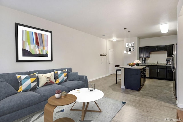 living room with light hardwood / wood-style floors and sink