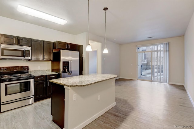 kitchen featuring light stone countertops, dark brown cabinets, stainless steel appliances, a center island, and hanging light fixtures