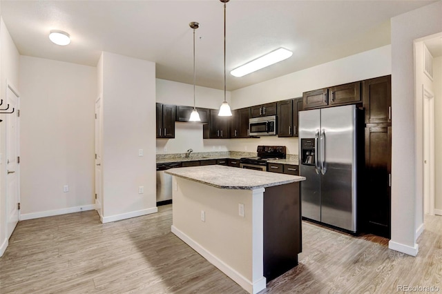 kitchen featuring pendant lighting, a kitchen island, stainless steel appliances, and dark brown cabinets