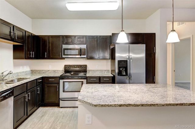 kitchen featuring pendant lighting, stainless steel appliances, dark brown cabinets, and sink