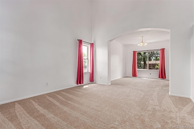 12825 Forest Way, Thornton, CO 80241 - carpeted spare room featuring arched walkways and a chandelier