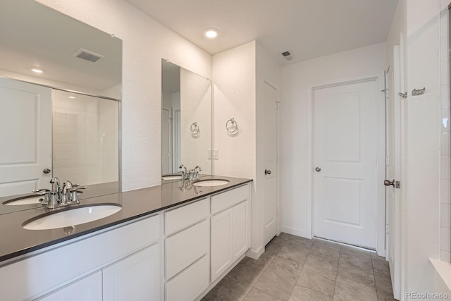 bathroom featuring double vanity, visible vents, and a sink