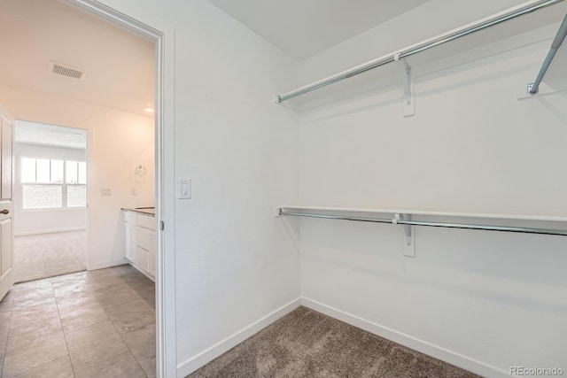 spacious closet with light colored carpet and visible vents