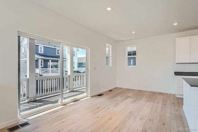 interior space featuring light wood-style flooring, plenty of natural light, and visible vents