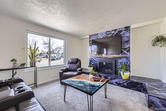 living room featuring a textured ceiling, carpet floors, a fireplace, and baseboards