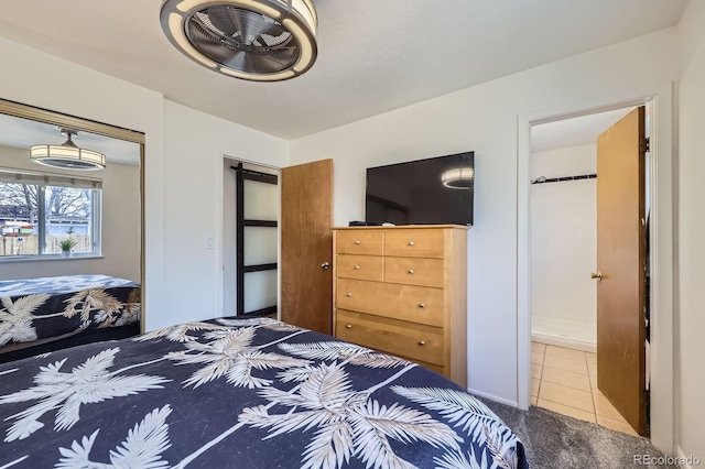 bedroom featuring carpet floors, a closet, ensuite bathroom, and tile patterned floors