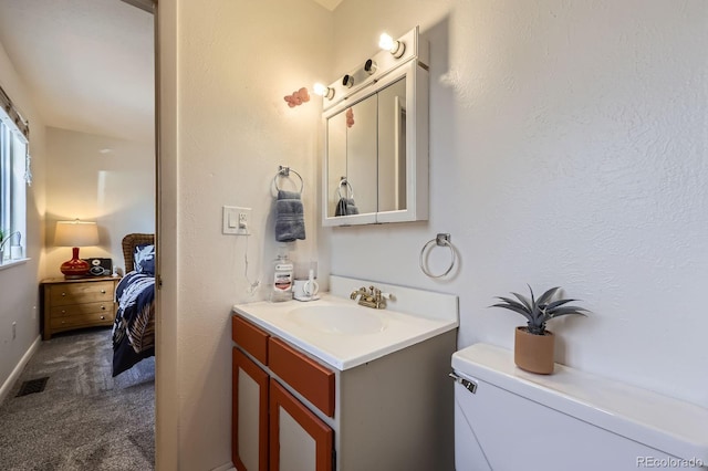 ensuite bathroom with visible vents, connected bathroom, and vanity