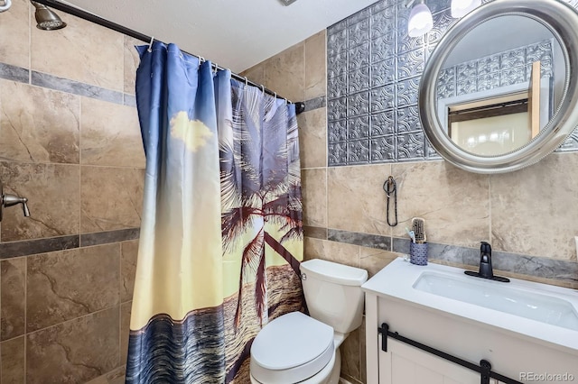 full bathroom with toilet, a tile shower, tile walls, and vanity