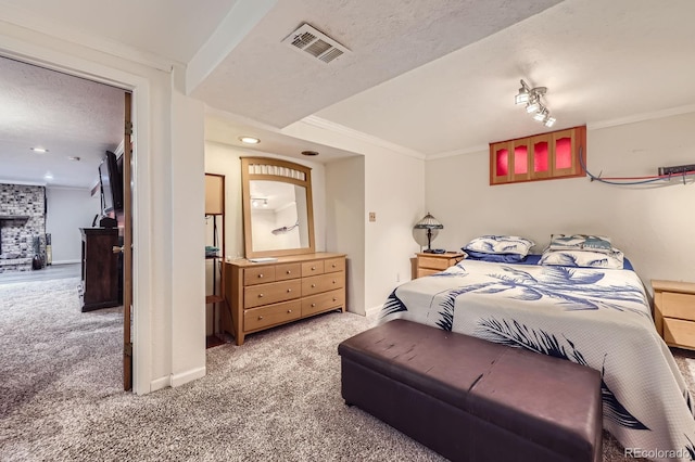 bedroom featuring a large fireplace, visible vents, baseboards, crown molding, and carpet flooring