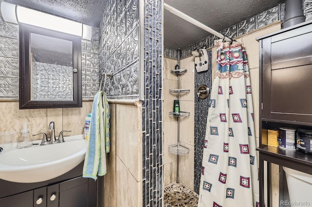 bathroom with a shower stall, vanity, and a textured ceiling