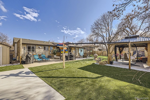 view of yard featuring a storage shed, a patio, an outbuilding, fence, and a gazebo