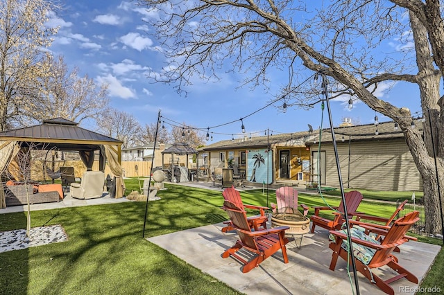 view of yard with a gazebo, a patio, fence, and an outdoor living space with a fire pit