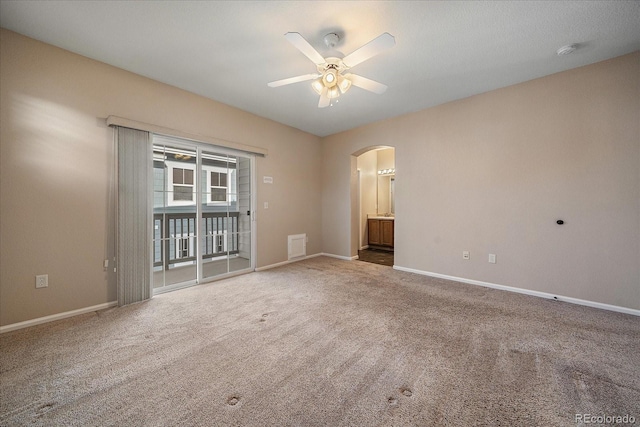 unfurnished room with baseboards, a ceiling fan, carpet flooring, and arched walkways