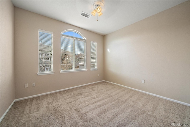 empty room featuring visible vents, carpet flooring, and baseboards