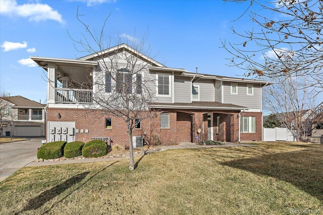 exterior space featuring central AC, fence, brick siding, a balcony, and a front yard