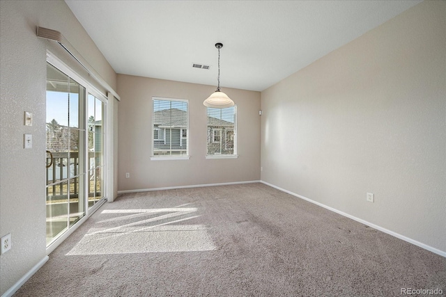 carpeted empty room featuring baseboards and visible vents