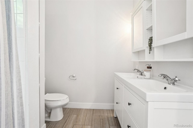4603 W 33rd Ave, Denver, CO 80212 - bathroom featuring toilet, baseboards, double vanity, and wood finished floors