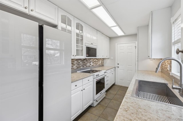 kitchen with high end white range, sink, and white cabinets